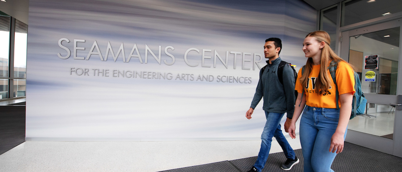 Students walking past a Seamans Center sign